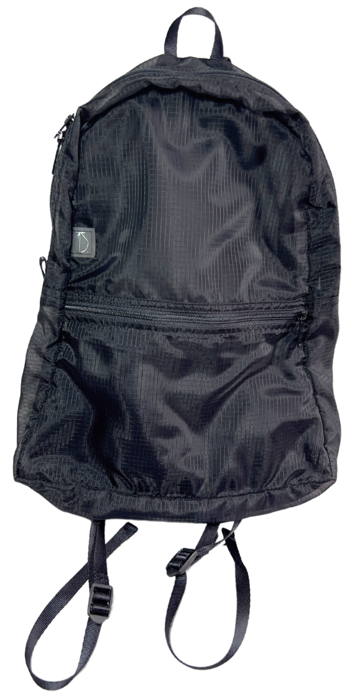 Front of the unisex MINImalist backpack. It is black in color and made of sheer nylon fabric. Backpack is empty.