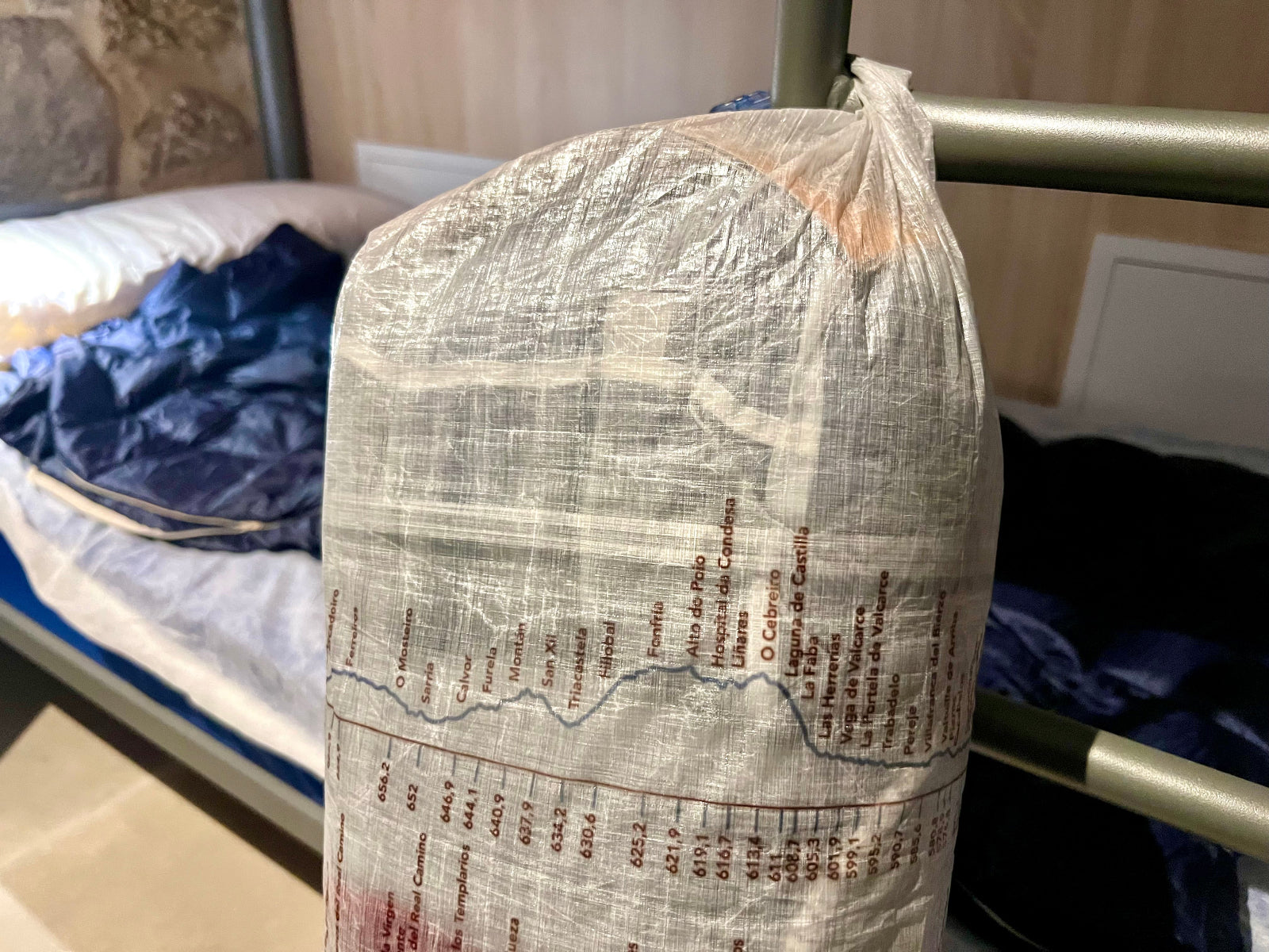 Dyneema Rolltop hangs on bunk bed ladder. Features camino frances profile with kilometers